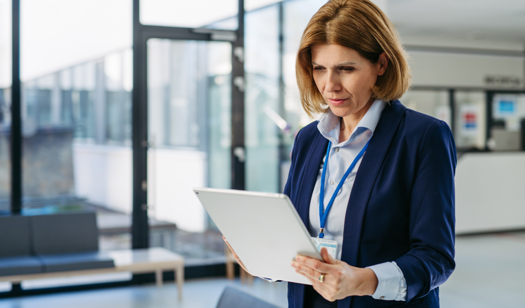 Woman reviewing content on a laptop in an office setting, representing MLR content management review